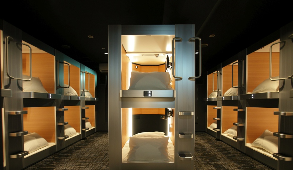 Banks of capsule berths along a shared passage in an Osaka capsule hotel.