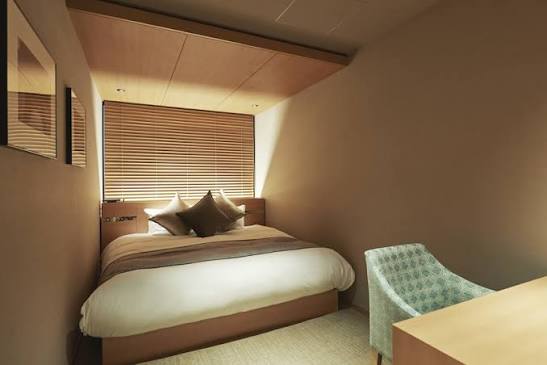 A row of cabin doors along a quiet passage in an Osaka cabin hotel.