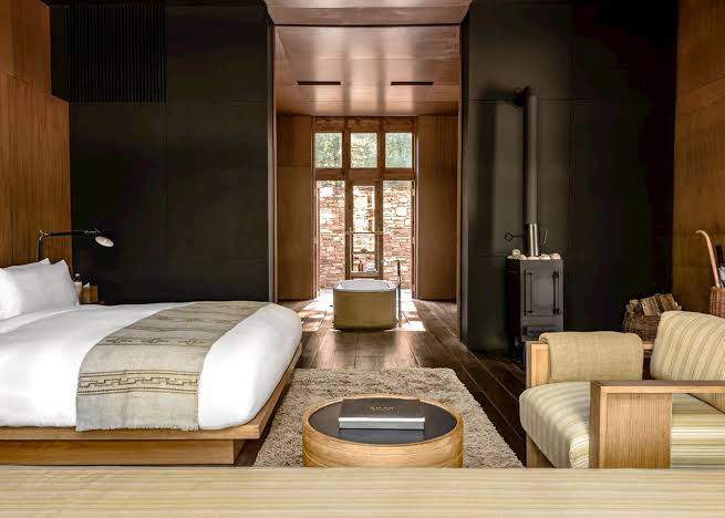 A rammed earth lodge standing among pines above the Paro valley in Bhutan.
