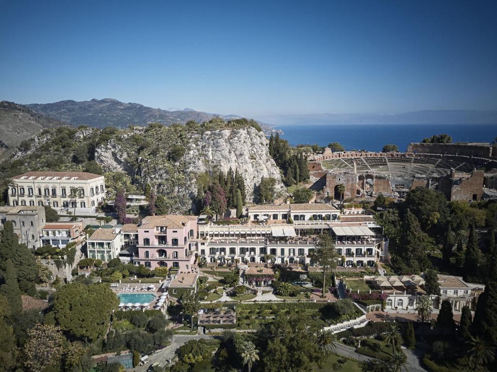 Terraces of a nineteenth-century Sicilian hotel stepped down a hillside above the bay.